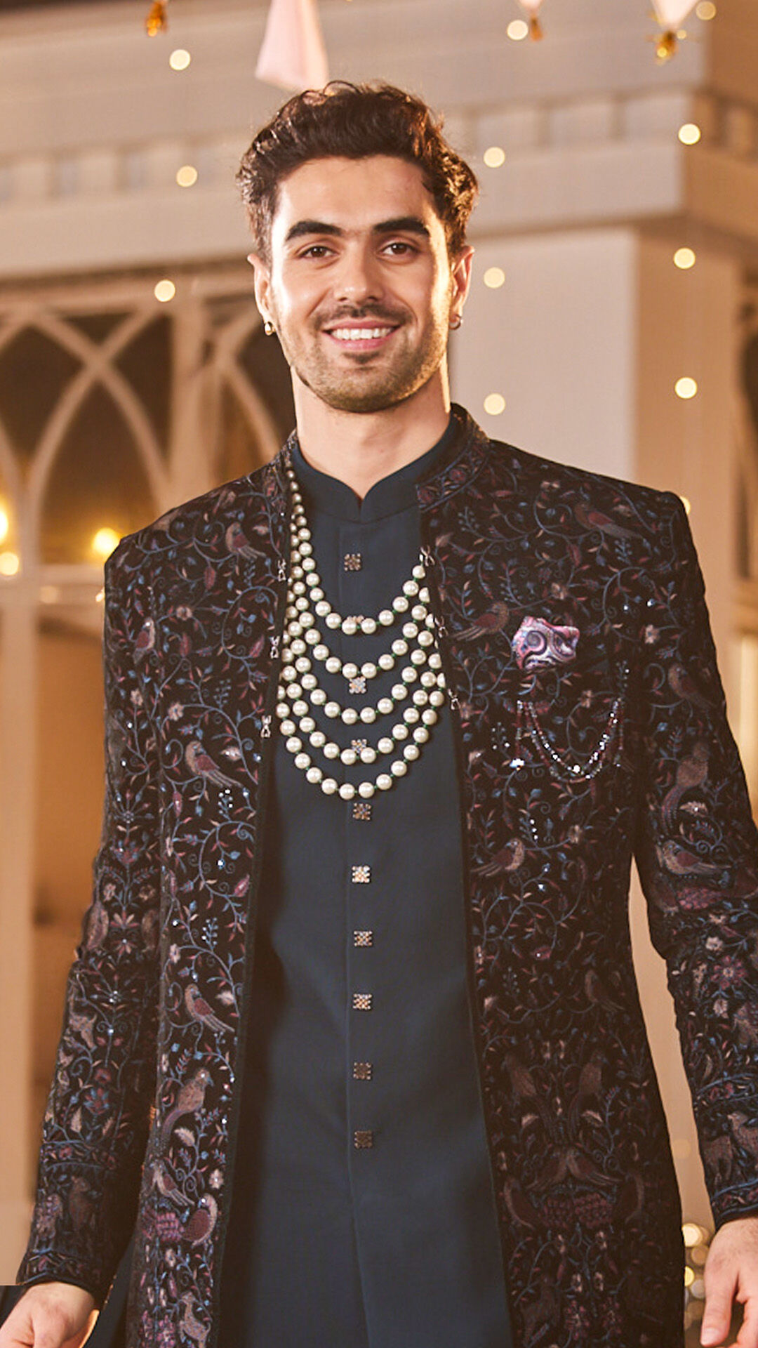 Groom wearing a blue kurta and white varmala during the wedding ceremony